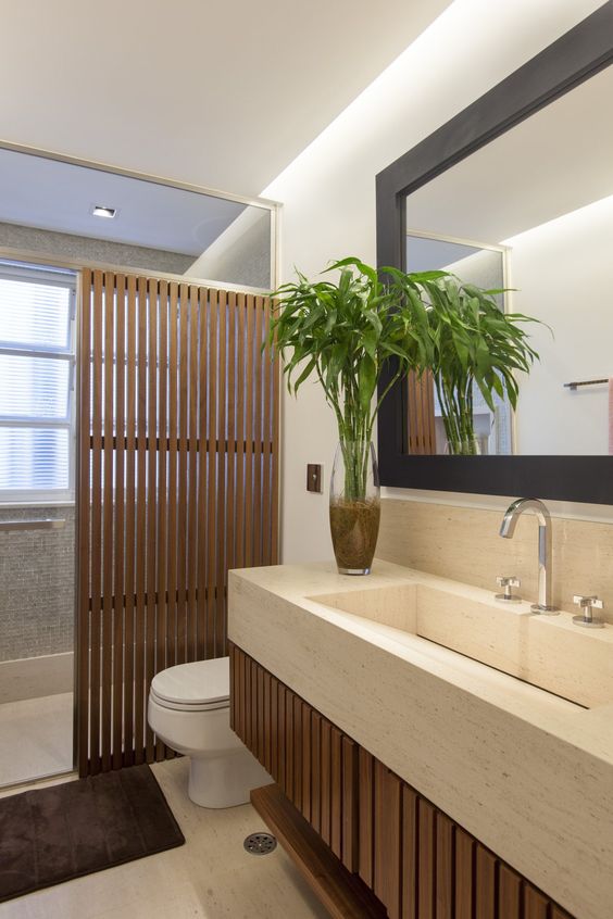 Banheiro elegante com mistura de vários elementos, como madeira, pastilha e mármore. 