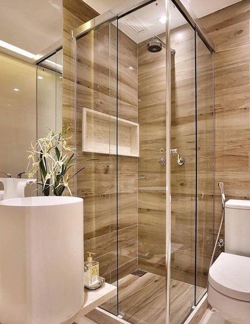 Banheiro planejado pequeno com revestimento de madeira.