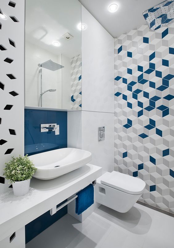 Banheiro moderno com revestimento geométrico na cor azul, cinza e branca.