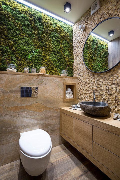Banheiro pequeno com mescla de diversos revestimentos em pedra, mármore e musgo.