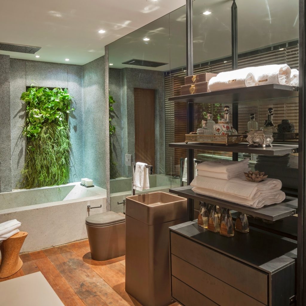 Banheiro com revestimento cinza com vidros e cuba.