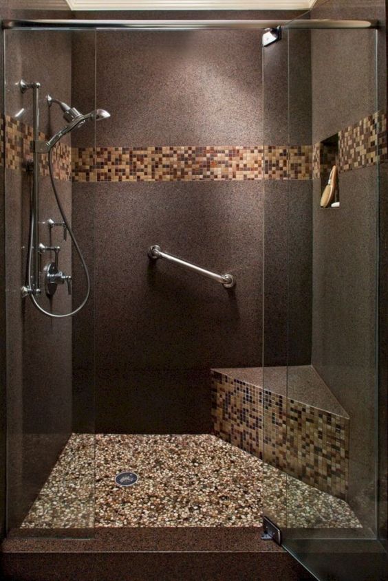 Banheiro moderno e escuro com pastilhas de tons de marrom.