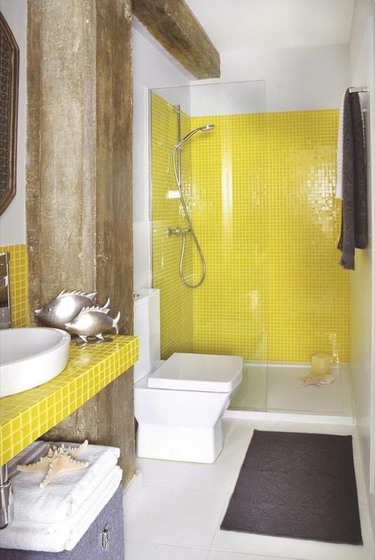Banheiro decorado com peixes, estrelas do mar e pastilhas amarelas.