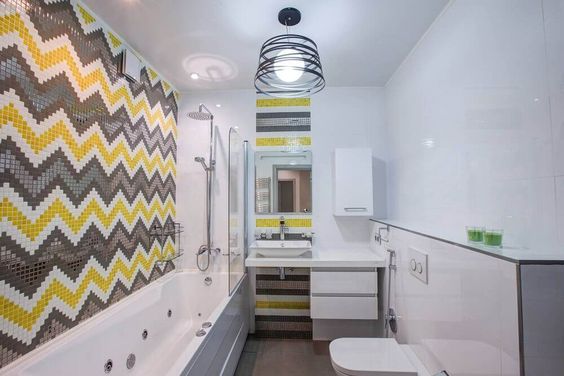 Banheiro com pastilha em duas paredes e postas de formas diferentes.
