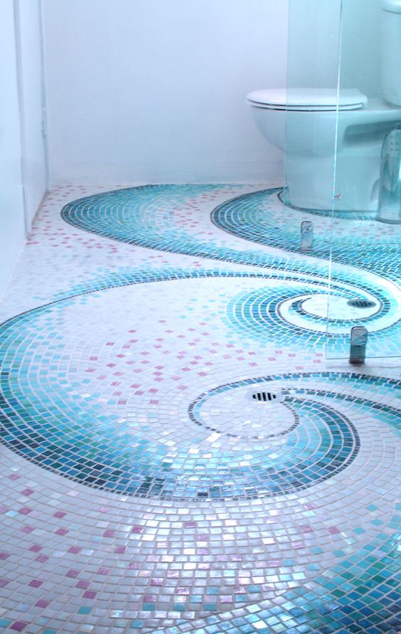 Chão de banheiro decorado com pastilhas desenhando ondas em azul e branco.