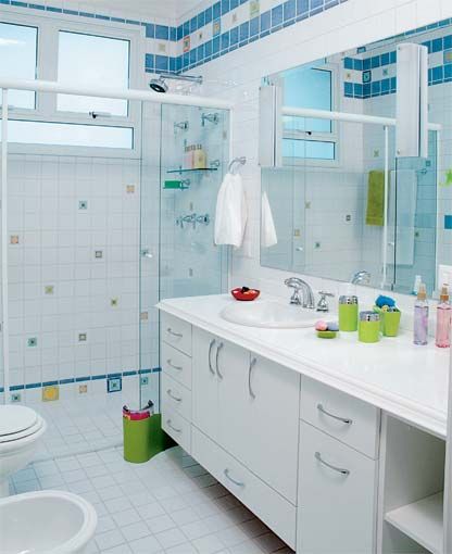 Banheiro branco com detalhes coloridos de pastilha.