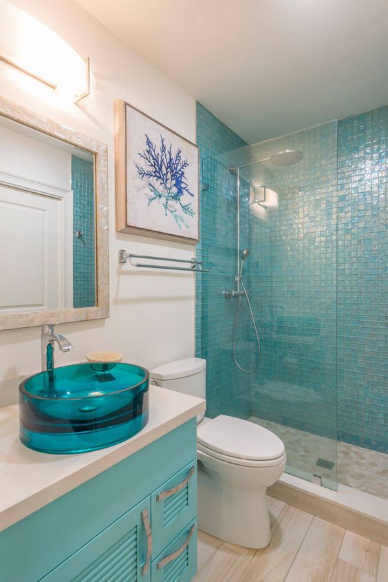 Banheiro com pia, armário, quadro e pastilha em azul.