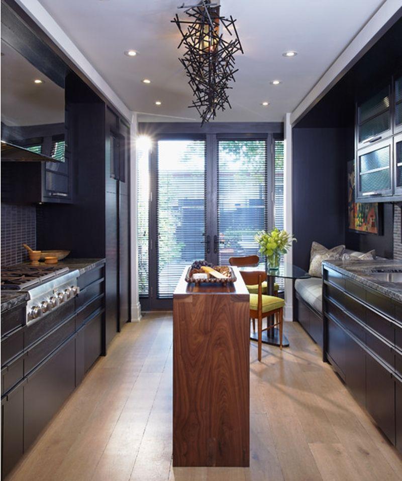 Cozinha planejada preta com mesa de madeira.