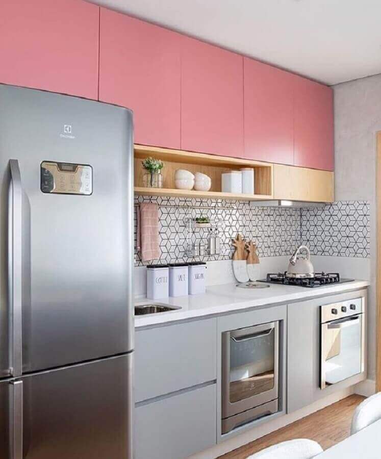 Cozinha com azulejo com estampa geométrica e armários rosa.