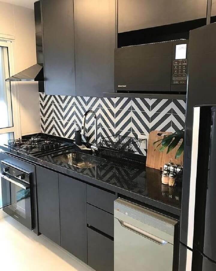 Cozinha preta decorada com azulejo com estampa geométrica.