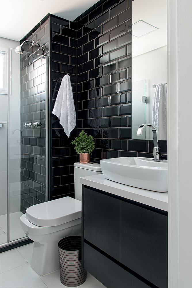Banheiro simples preto e branco com azulejo de tijolinho preto.