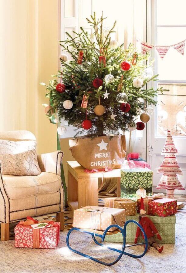 Decoração de natal para sala pequena com árvore natural e árvore de tecido.