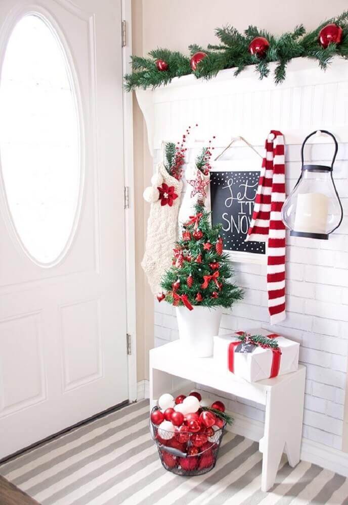 Decoração de natal para sala pequena com meias, bolas de natal e árvore.