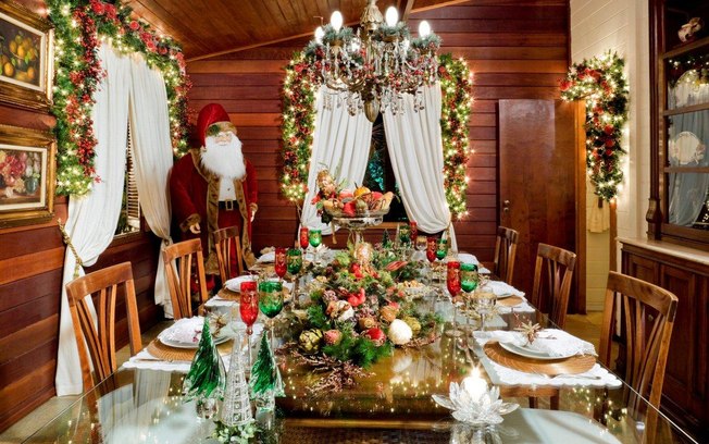 Decoração de natal para sala de jantar com arranjo de mesa e taças natalinas.