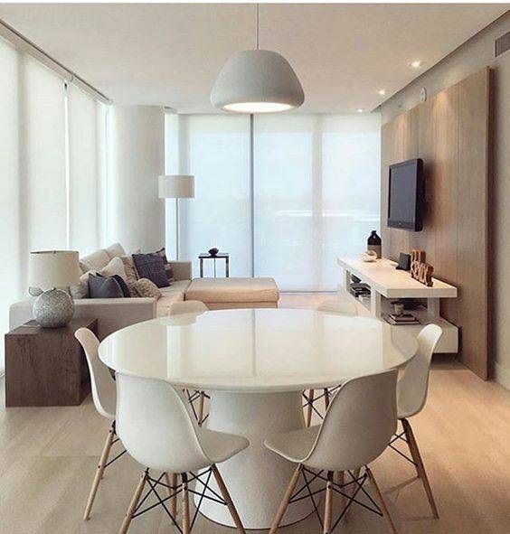 sala de estar moderna com mesa redonda e painel de madeira