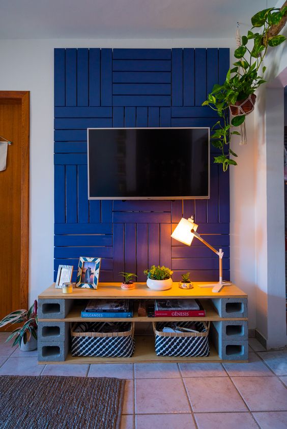 Painel de tv feito com paletes azuis.