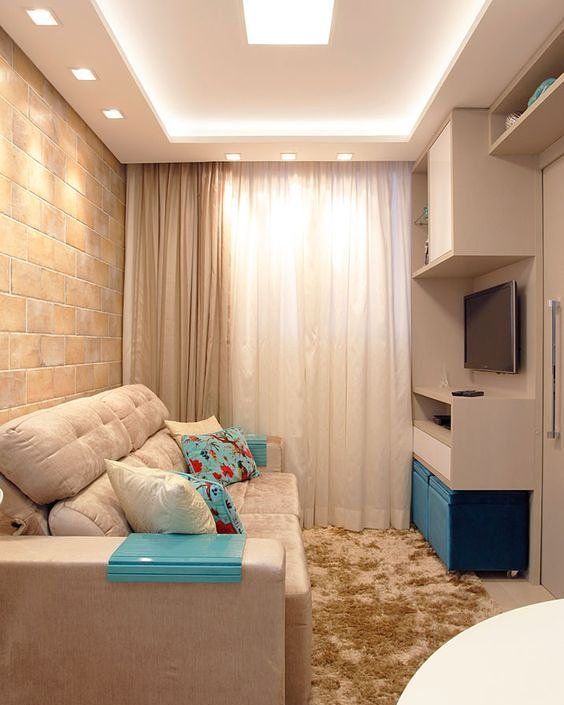 Decoração de sala de estar pequena com cores neutras e detalhes azuis.