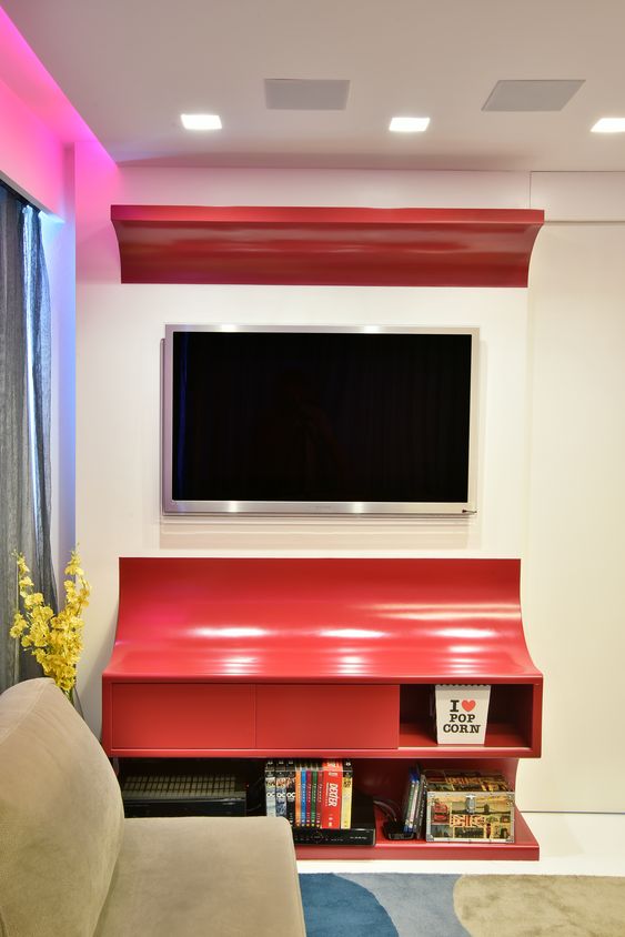 Sala de estar pequena com móvel vermelho.