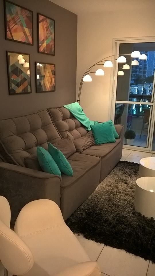 Sala de estar pequena com almofadas verdes.