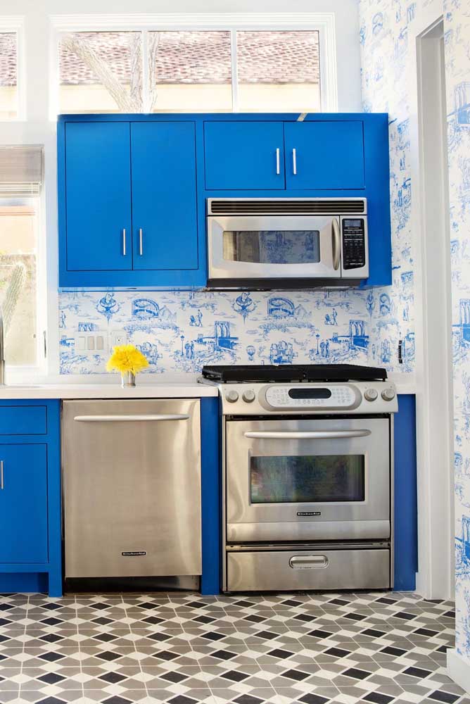 Decoração com armários azuis e piso decorado.