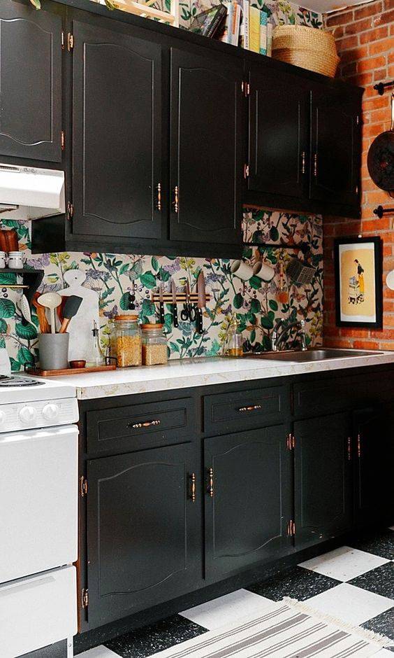 Cozinha preta com papel de parede com estampa floral.