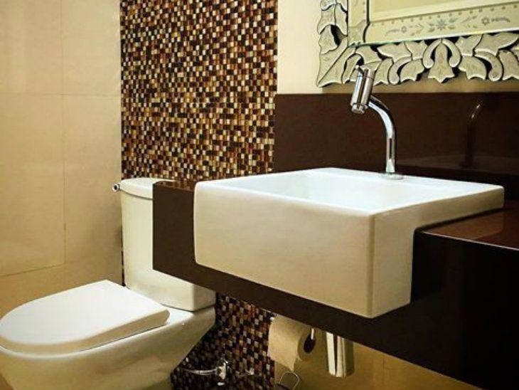 banheiro com bancada em granito marrom absoluto e pastilhas coloridas na parede